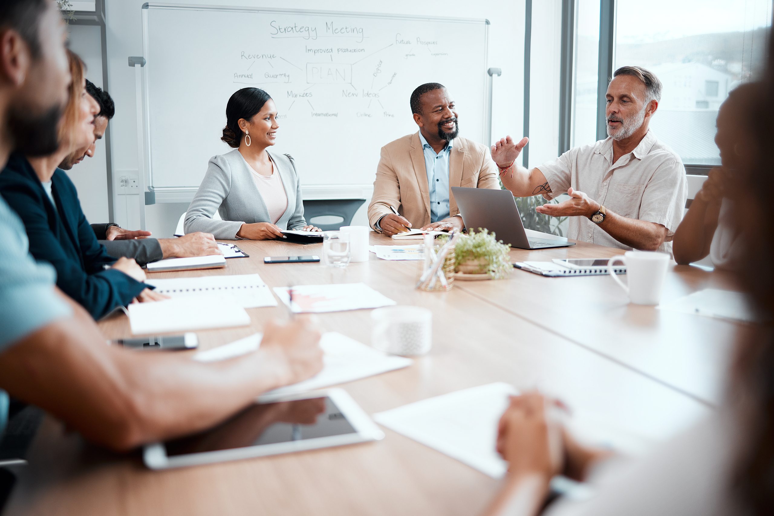 a group of leaders listening to their boss during a business meeting.